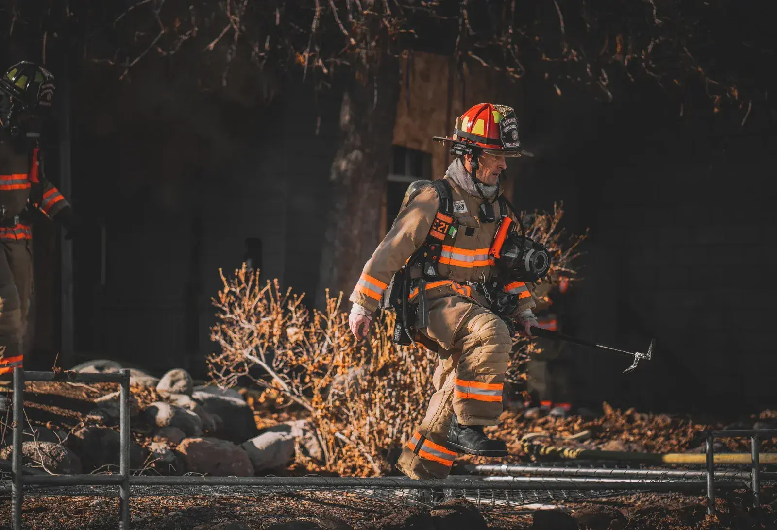Two Reno firefighters carrying tools at dawn